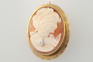 A 14ct yellow gold oval carved cameo portrait pendant, the sitter wearing a diamond pendant, 35mm 10.4 grams 