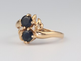 A 14ct yellow gold crossover sapphire and diamond ring, the sapphires each approx. 0.20ct, the diamonds 0.01ct, 2.6 grams, size M 