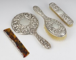 A Victorian style silver dressing table set comprising hand mirror, clothes brush, hair brush and comb, Birmingham 1958 