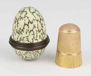 A yellow gold, testing as 18ct, thimble, 3.4 grams contained in an enamelled egg shaped box 