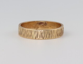 An 18ct yellow gold bark effect wedding band, 2.6 grams, size K 