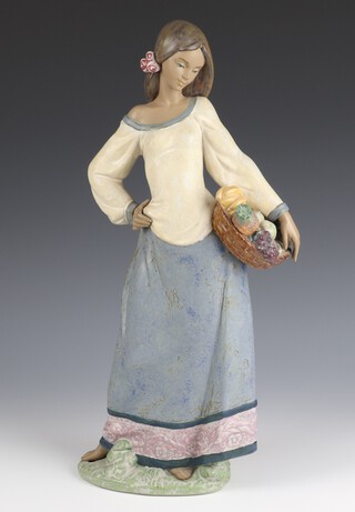 A Lladro matte finish figure of a girl carrying a basket of fruit 2229, 43cm 