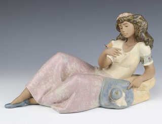 A Lladro matte finish figure of a reclining lady with a bird 2051 20cm 