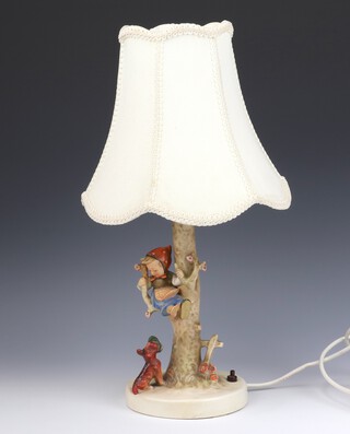 A Hummel table lamp in the form of a girl sitting on a tree trunk, a dog before her, printed marks, fitted for electricity 22cm 