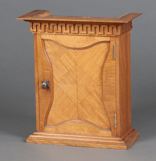 A Victorian Continental satinwood cabinet having a moulded cornice with Grecian Key decoration, fitted pigeon holes and 2 short drawers, enclosed by a quarter veneered panelled door, raised on a platform base 47cm h x 42cm w x 20cm d 