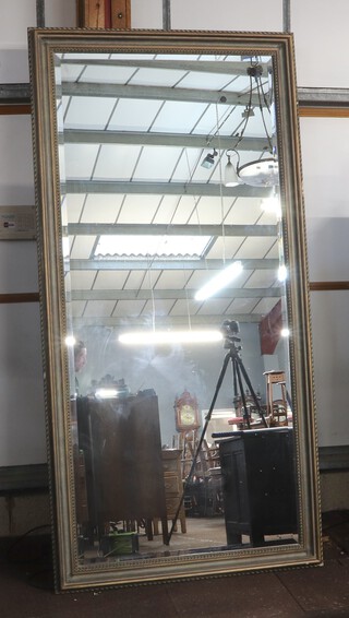 A large 20th Century rectangular bevelled plate mirror contained a decorative silvered frame 244cm x 124cm 