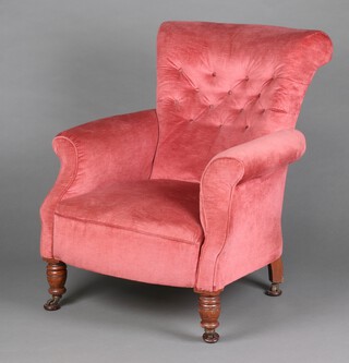 A Victorian armchair upholstered in rose pink buttoned material on turned supports with metal casters 88cm h x 77cm w x 59cm d (seat 30cm x 37cm) 