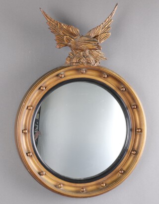 A Regency style convex plate wall mirror contained a circular ball studded frame surmounted by an eagle 40cm diam. 