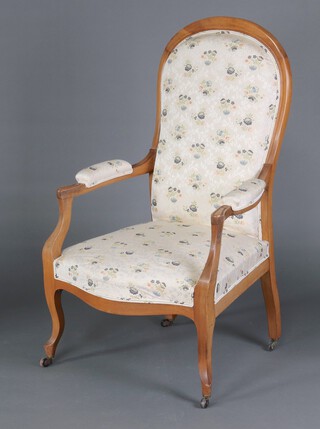 A Victorian bleached mahogany open arm chair, the seat and back upholstered in tapestry material, raised on cabriole supports with ceramic casters 115cm h x 68cm w x 55cm d (seat 29cm x 32cm) 