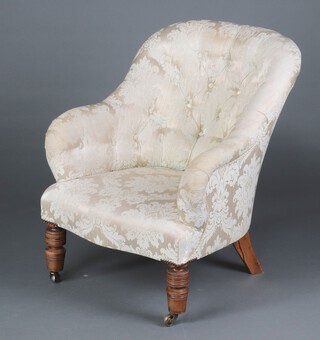 A Victorian tub back armchair upholstered in cream floral patterned material, raised on turned supports with ceramic casters 85cm h x 70cm w x 67cm d (seat 30cm x 36cm) 