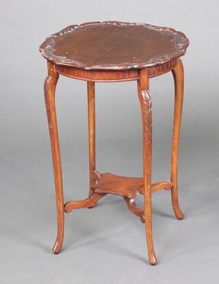 An Edwardian carved circular mahogany occasional table, raised on cabriole supports with shaped undertier 66cm h x 46cm diam. 