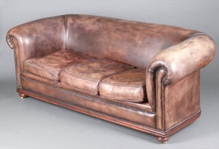 A 3 seat Chesterfield upholstered in brown leather, raised on bun feet 74cm h x 199cm w x 86cm d (seat 126cm x 48cm)  