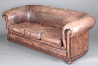 A 3 seat Chesterfield upholstered in brown leather, raised on bun feet 74cm h x 199cm w x 86cm d (seat 126cm x 48cm) 