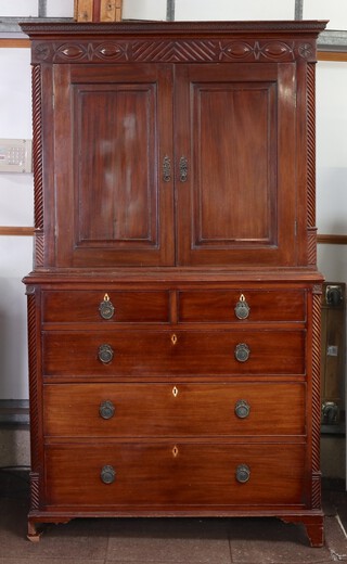A Victorian mahogany linen press, the interior fitted a shelf enclosed by a panelled door, the base fitted 2 short and 3 long drawers, raised on bracket feet 216cm h x 123cm w x 56cm d 