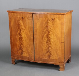 An Edwardian Georgian style inlaid and crossbanded mahogany bow front side cabinet, enclosed by panelled door, raised on bracket feet 98cm h x 106cm w x 56cm d 