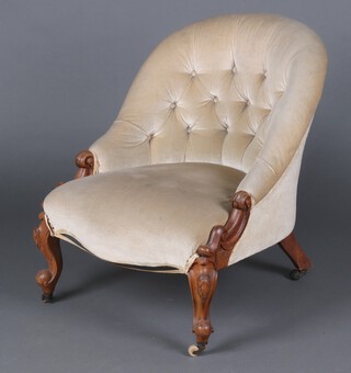 A Victorian carved mahogany, show frame tub back armchair upholstered in mushroom coloured buttoned material, raised on cabriole supports 69cm h x 55cm w (seat 23cm x 30cm) 