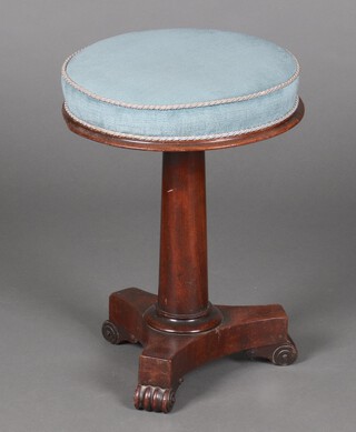 A William IV circular piano stool upholstered in blue material, raised on turned column and triform base with scrolled feet 50cm h x 36cm diam.  