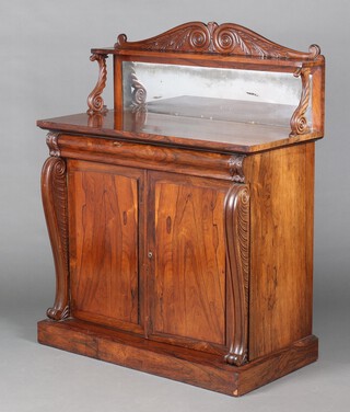 A Regency rosewood chiffonier with raised mirrored back fitted a shelf, the base with drawer above cupboard fitted 2 drawers, enclosed by a pair of panelled doors and scrolls to the sides, raised on a platform base 123cm h x 100cm w x 46cm d 