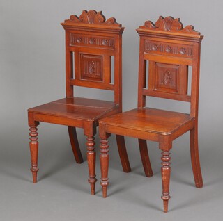 A pair of Edwardian carved mahogany hall chairs with shaped backs and seats, raised on turned supports 91cm h x 43cm w x 36cm d (seats 24cm x 34cm) 