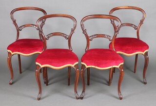 A set of 4 Victorian rosewood spoon back chairs with arch shaped mid rails and over stuffed seats, raised on cabriole supports 83cm h x 42cm w x 40cm d 