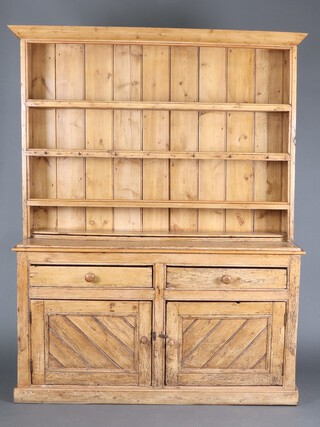 A 19th Century pine "Irish" dresser with moulded cornice, fitted 3 shelves, the base fitted 2 drawers above double cupboard enclosed by panelled doors, raised on a platform base, 201cm h x 154cm w x 45cm d 