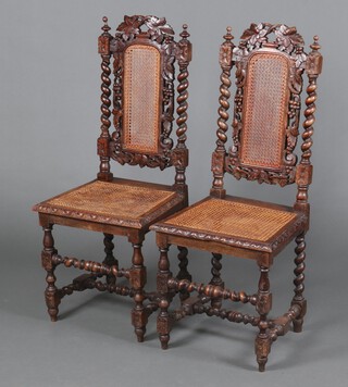 A pair of Victorian Carolean style carved oak high backed chairs with woven cane backs and seats, raised on spiral turned supports 109cm h x 46cm w x 40cm (23cm x 23cm) 