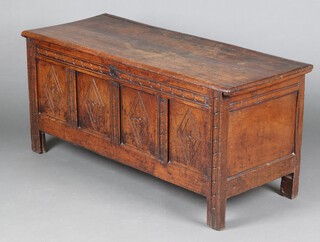 A 17th Century carved oak coffer of panelled construction the interior fitted a glove box with iron lock, original polished steel key and long steel hinges, the front panels carved diamonds 61cm h x 134cm w x 53cm d 