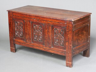 A 17th century William and Mary oak coffer with hinged lid, the front with four panels carved in low relief with birds amongst tulips, within chequer strung borders, on through stiles, 69cm h x 124cm w x 57cm d