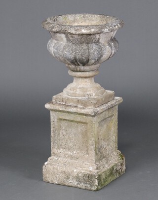 A well weathered circular concrete garden urn raised on a square pedestal base 70cm x 41cm (In 3 sections) 