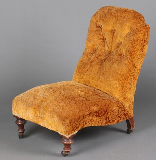 A Victorian nursing chair upholstered in gold sculpted material raised on turned supports 78cm h x 50cm w x 61cm d 