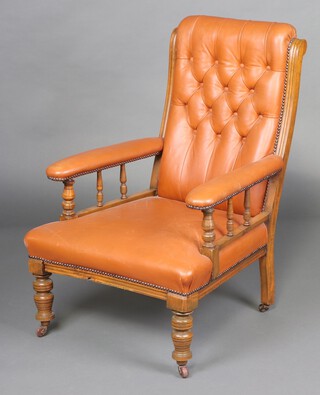 A Victorian mahogany armchair with spindle turnings, the seat and back upholstered in brown leather, raised on turned supports 99cm h x 66cm w x 76cm d (seat 35cm x 46cm)