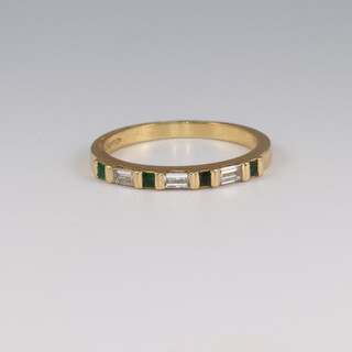 An 18ct yellow gold baguette cut diamond and princess cut emerald ring, size K 1/2, 2.2 grams, the diamonds approx. 0.03ct, the emeralds approx. 0.03ct 