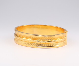 A 24ct yellow gold engraved bangle 28.5 grams internal diameter 5cm by 4cm