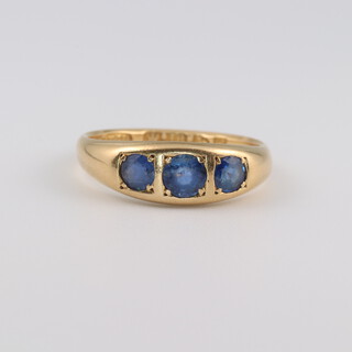 An 18ct yellow gold 3 stone sapphire ring, size Q 1/2, 4.8 grams 