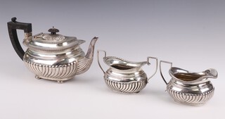 A matched 3 piece semi-fluted silver tea set with ebony mounts, the teapot Birmingham 1898 584 grams gross, the jug Sheffield 1927 160 grams, the sugar bowl (rubbed date letter) 126 grams 