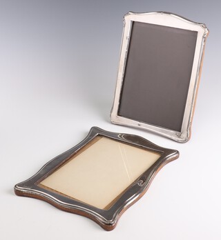 A silver serpentine photograph frame Birmingham 1949 26cm, a dome topped ditto (rubbed marks) 25cm 