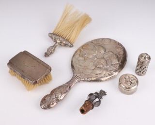 An Edwardian repousse silver Reynolds Angel hand mirror, Birmingham 1904, 2 silver mounted brushes, a pepper, toilet jar and stopper  