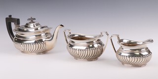 A silver demi-fluted 3 piece tea set with ebony mounts, Sheffield 1924 and 1925, 1202 grams gross 