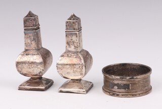 A pair of silver baluster pepperettes London 1906 7cm, weighted and a silver napkin ring Birmingham 1920, gross weight 72 grams 