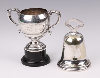 A silver presentation trophy cup London 1934 with presentation inscription 7cm, 94 grams, together with a silver plated hand bell 