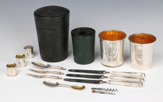 A good 19th Century Irish travelling set by James Le Bas comprising 2 silver beakers with gilt interiors, 2 silver fork ends, 2 steel knife blades, a silver dessert spoon, 3 silver handles, a double ended spoon, a cylindrical 3 section condiment set of salt, pepper and mustard with gilt interiors and a steel corkscrew/pick, all with an armorial, contained in a Moroccan leather case, monogrammed, Dublin 1868