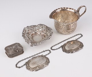 An Edwardian repousse silver pierced heart shaped bon bon dish rubbed marks 9cm, a silver jug, 2 spirit labels and a filigree box, 98 grams 