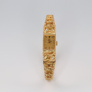 A lady's 18ct yellow gold Omega wristwatch on an open ditto bracelet, 30 grams including the glass 