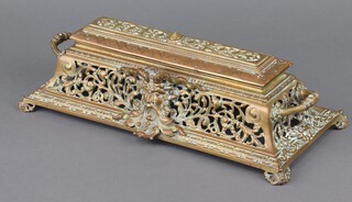 A Victorian rectangular pierced brass 2 bottle inkwell fitted 2 associated ceramic inkwells, the front decorated a grotesque figure 11cm x 37cm x 17cm, the base marked RDNO 71070 