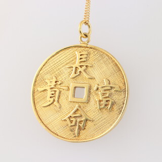 A 14ct yellow gold circular engine turned pendant with Chinese characters on a ditto 40cm chain, 8.1 grams 