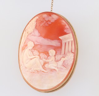 A 9ct yellow gold carved cameo brooch of figures before a temple 60mm 