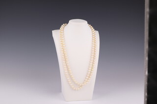 A double strand cultured pearl necklace with an 18ct white gold and diamond set cast, stamped Manning, each pearl 5mm, the diamonds approx. 0.07ct, 60cm 