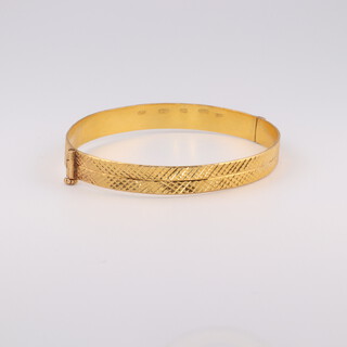 A 22ct yellow bold bright cut bangle 13.7 grams internal diameter 5.5cm by 4.5cm