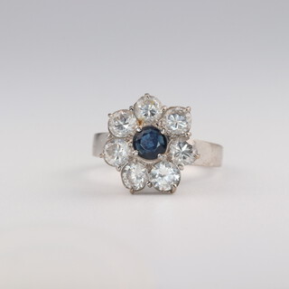 A 14ct white gold sapphire and diamond cluster ring, the sapphire 0.20ct, the brilliant cut diamonds 1ct, size N, 3.3 grams 