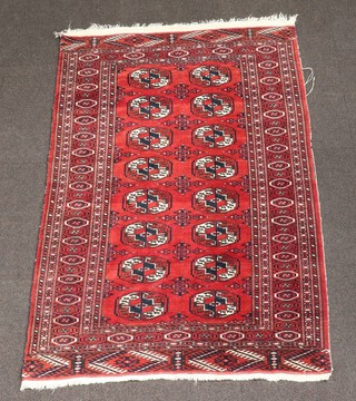 A red and blue Bokhara rug with 16 octagons to the centre within a multi row border 156cm x 101cm 